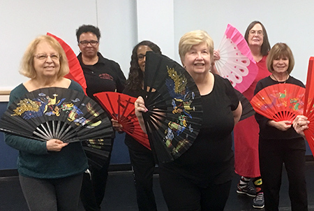 Participants in a tai chi fan workshop